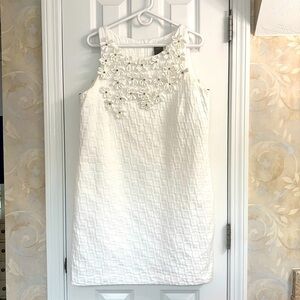 Taylor Elegant White Sleeveless Dress with Floral Embellishments and Gold Beads.